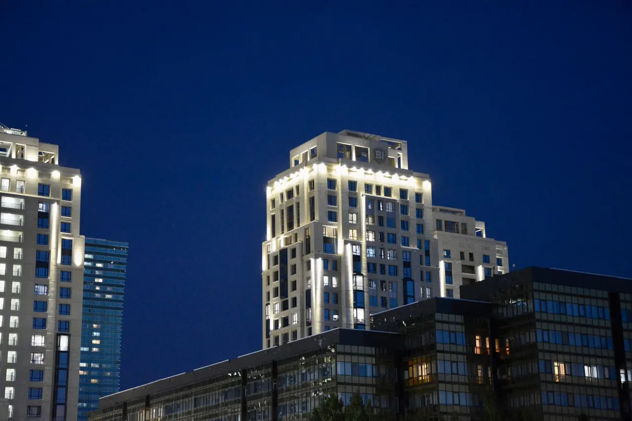 Tours de bureaux modernes au crépuscule avec contours lumineux, ciel bleu nuit